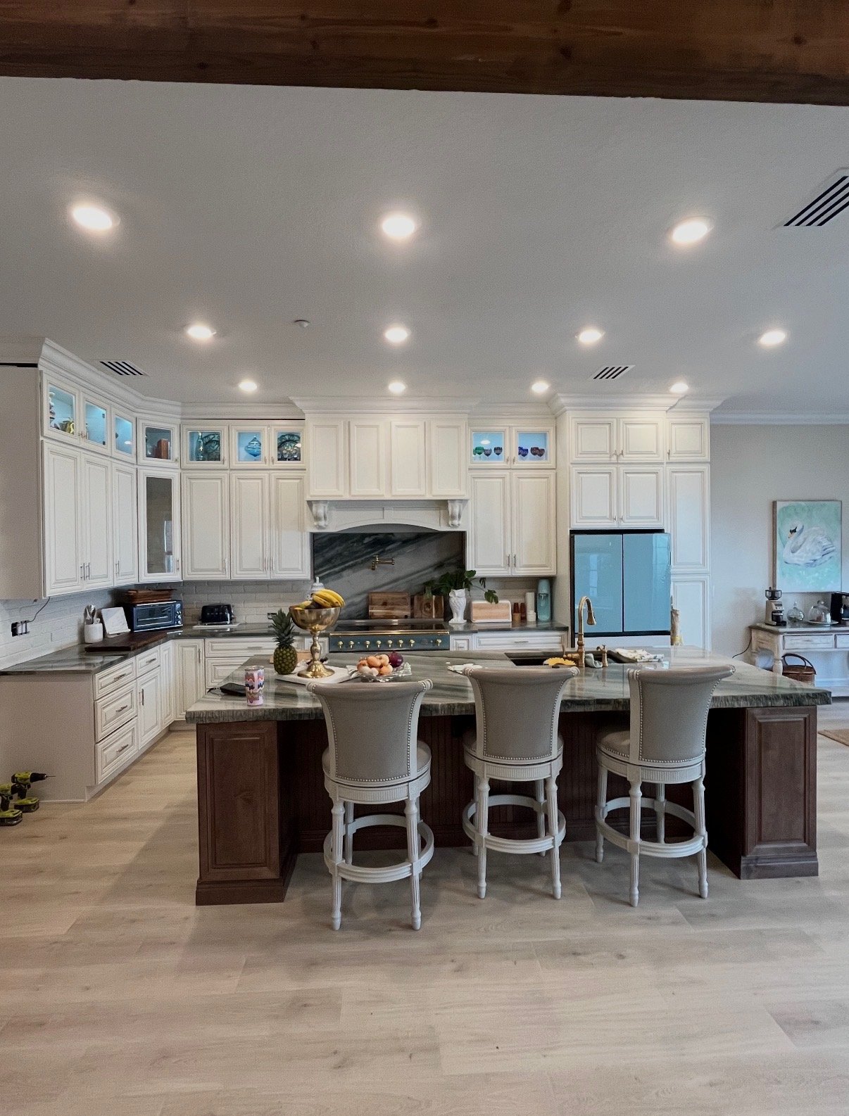 Custom kitchen with wood beam ceiling and waterfall marble island